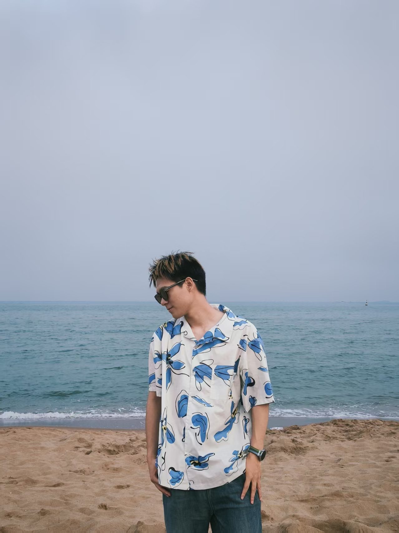 凌峰穿着蓝白衬衫站在海边